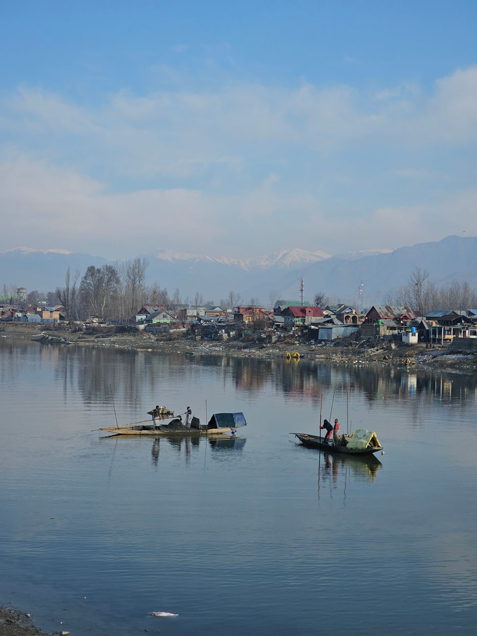 Fishing scene on Dal Lake with distant mountains